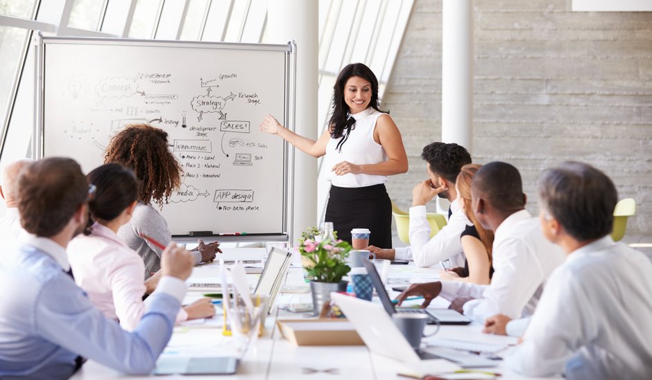 hispanic,businesswoman,leading,meeting,at,boardroom,table